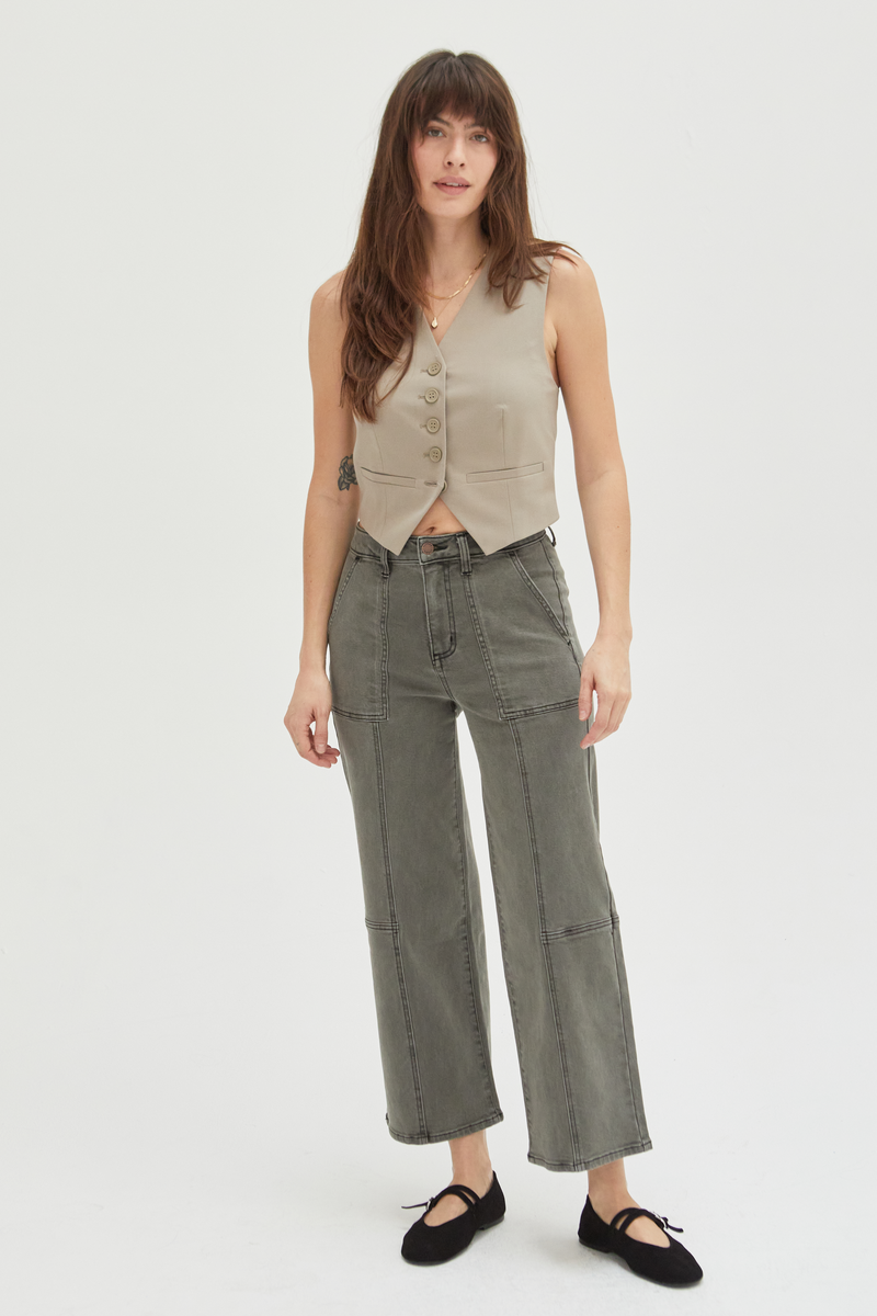 Model wearing wide-leg ankle crop jeans in an olive overdye wash, styled with a beige sleeveless top and black flats, showcasing a relaxed fit and cropped hem.