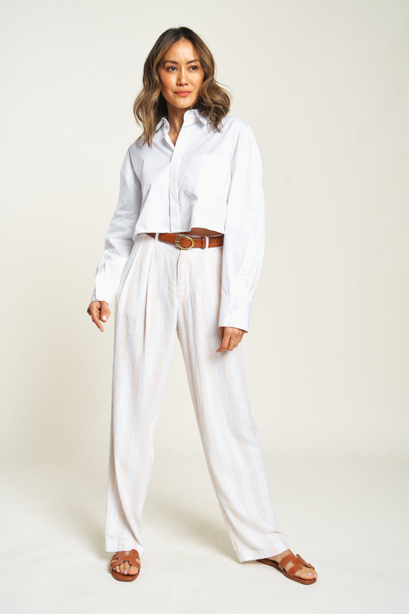 Woman wearing lightweight high-waisted dress pants with a white shirt. The perfect balance of comfort and style.