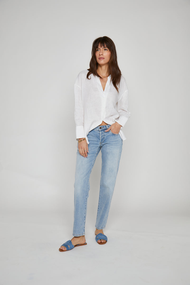Model styled in light wash straight leg jeans, paired with a white button-up shirt, front view showcasing the soft light denim and relaxed fit.