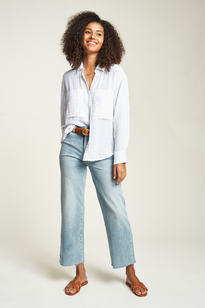 Lightweight white button-up top featuring long sleeves and a relaxed fit, perfect for casual or dressy occasions.