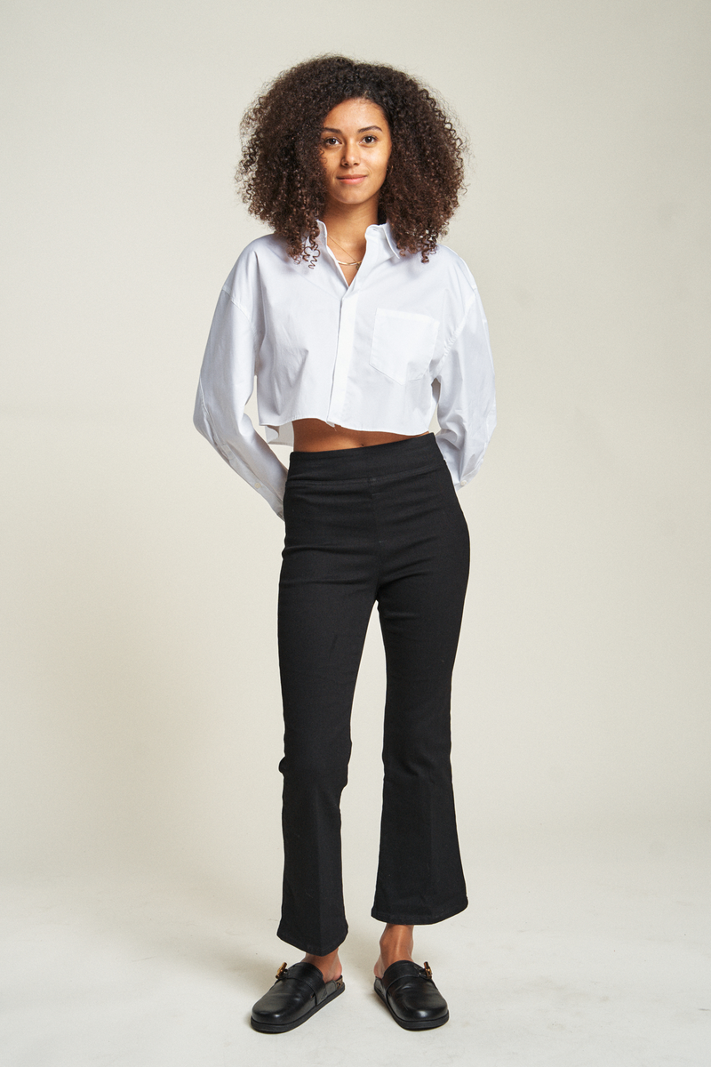 Cropped flare pull-on pants in black, model facing forward, showing relaxed fit and cropped hem just above the ankles.