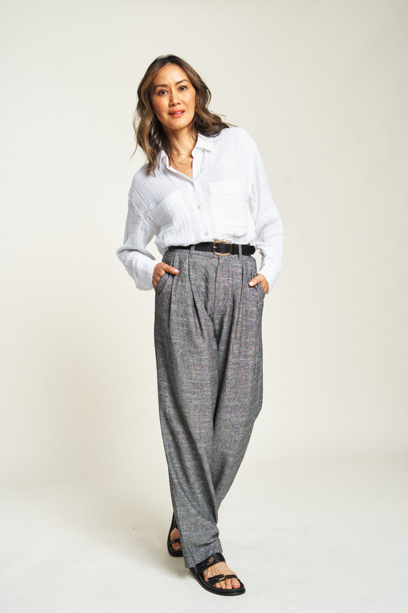 Woman wearing pleated trousers, facing forward. Lightweight 100% cotton, high-rise dress pants with pleats for a relaxed fit