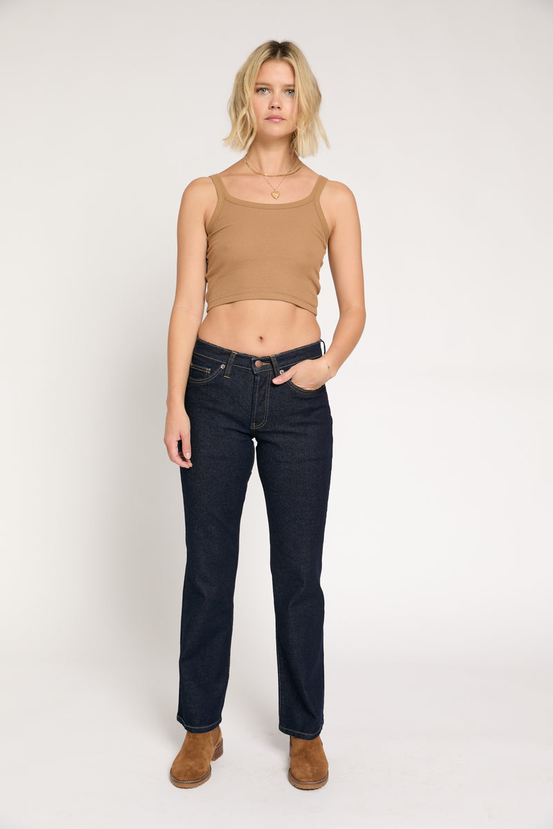 Model is standing with her hands in pockets, wearing high-rise vintage-inspired boot cut jeans. She is facing forward, showing a relaxed fit.