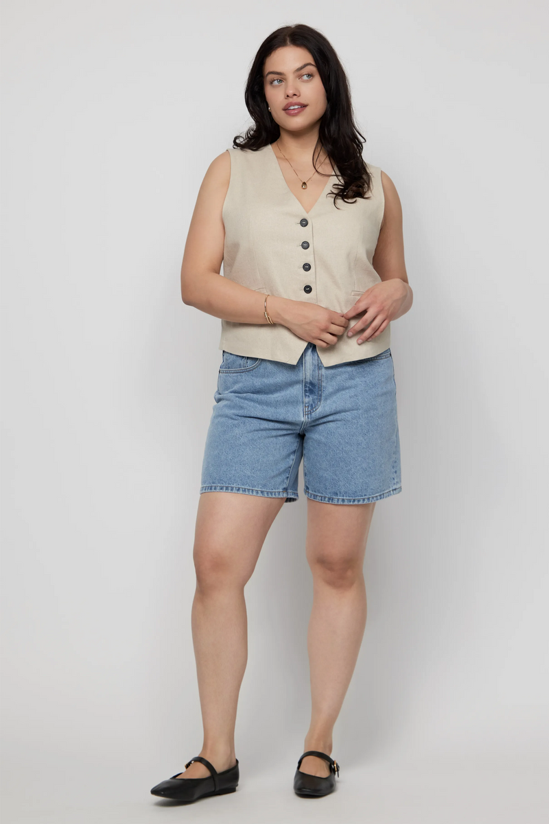 Plus-size woman in high-rise light wash denim shorts and sleeveless button-up top.