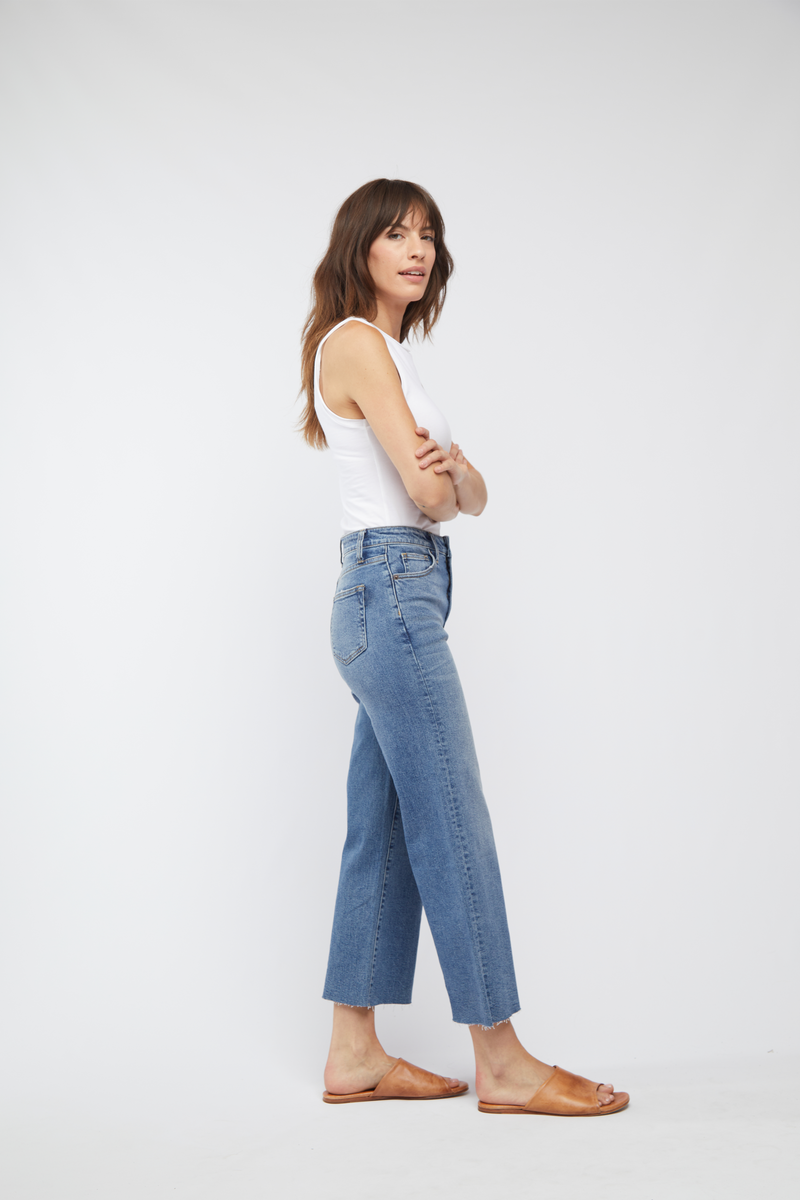 Side view of model in light wash wide leg jeans, showing off the relaxed fit and high waist.