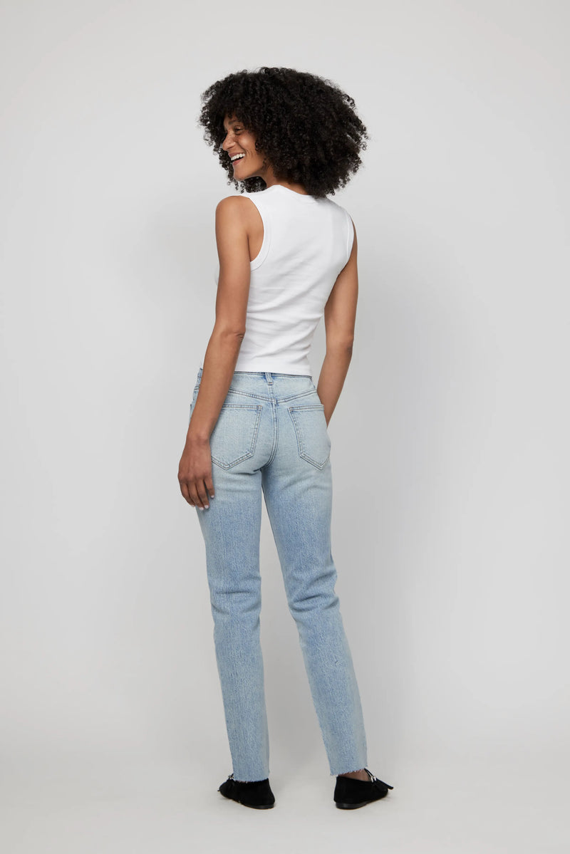 Back view of high-rise light wash relaxed jeans for women, styled with a white ribbed tank.