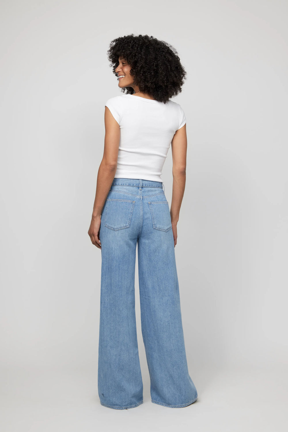 Back view of high-rise wide-leg denim jeans, showing full length and relaxed drape from the waist down.