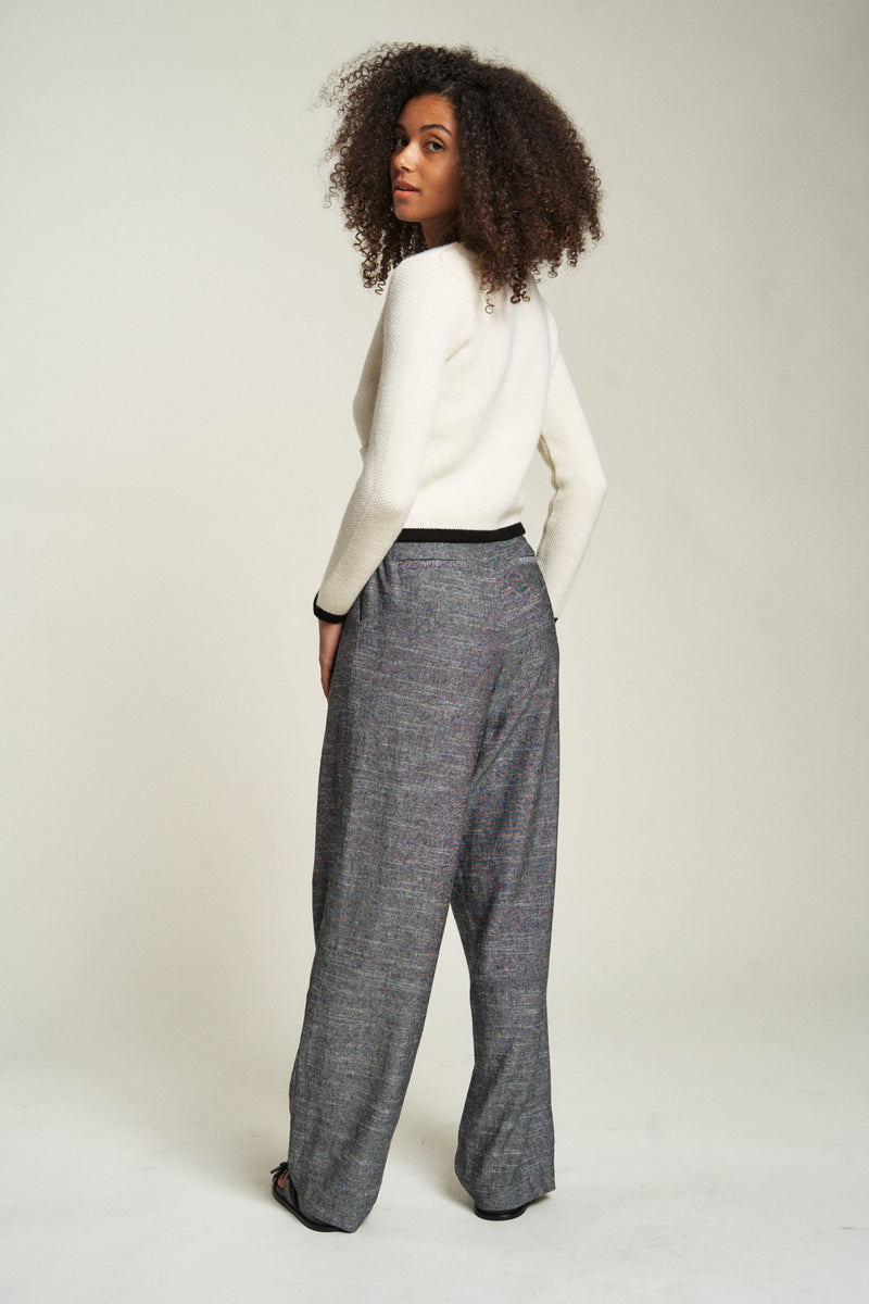 Woman facing backward, showcasing the back of the comfortable lightweight trousers. These high-waisted pants are versatile and breathable.