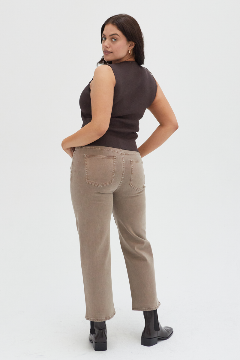 Back view of a plus-size model in brown wide-leg ankle crop jeans, highlighting the structured silhouette and clean design.