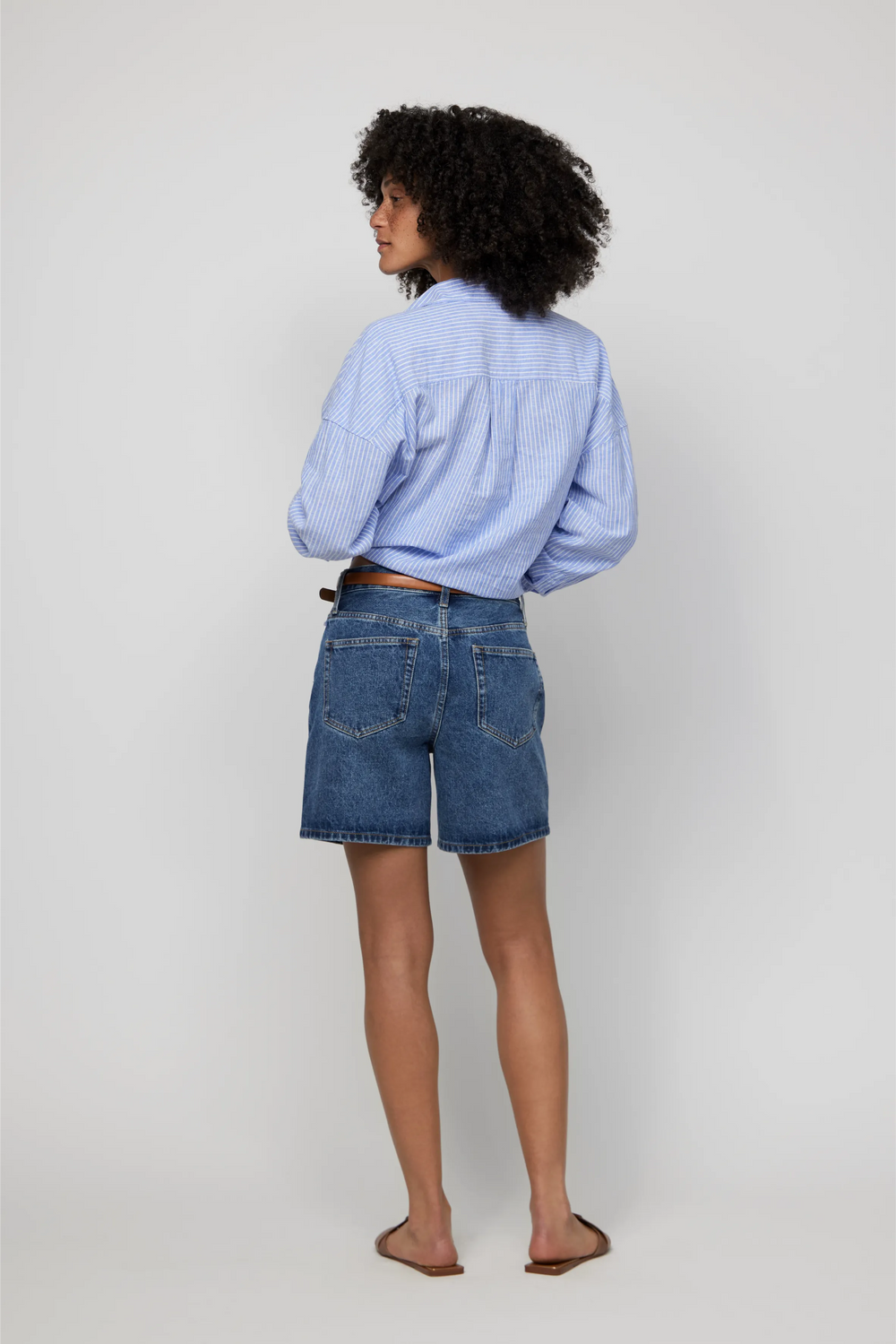 Back view of high-rise jean shorts for women in dark indigo wash with a relaxed, everyday fit.