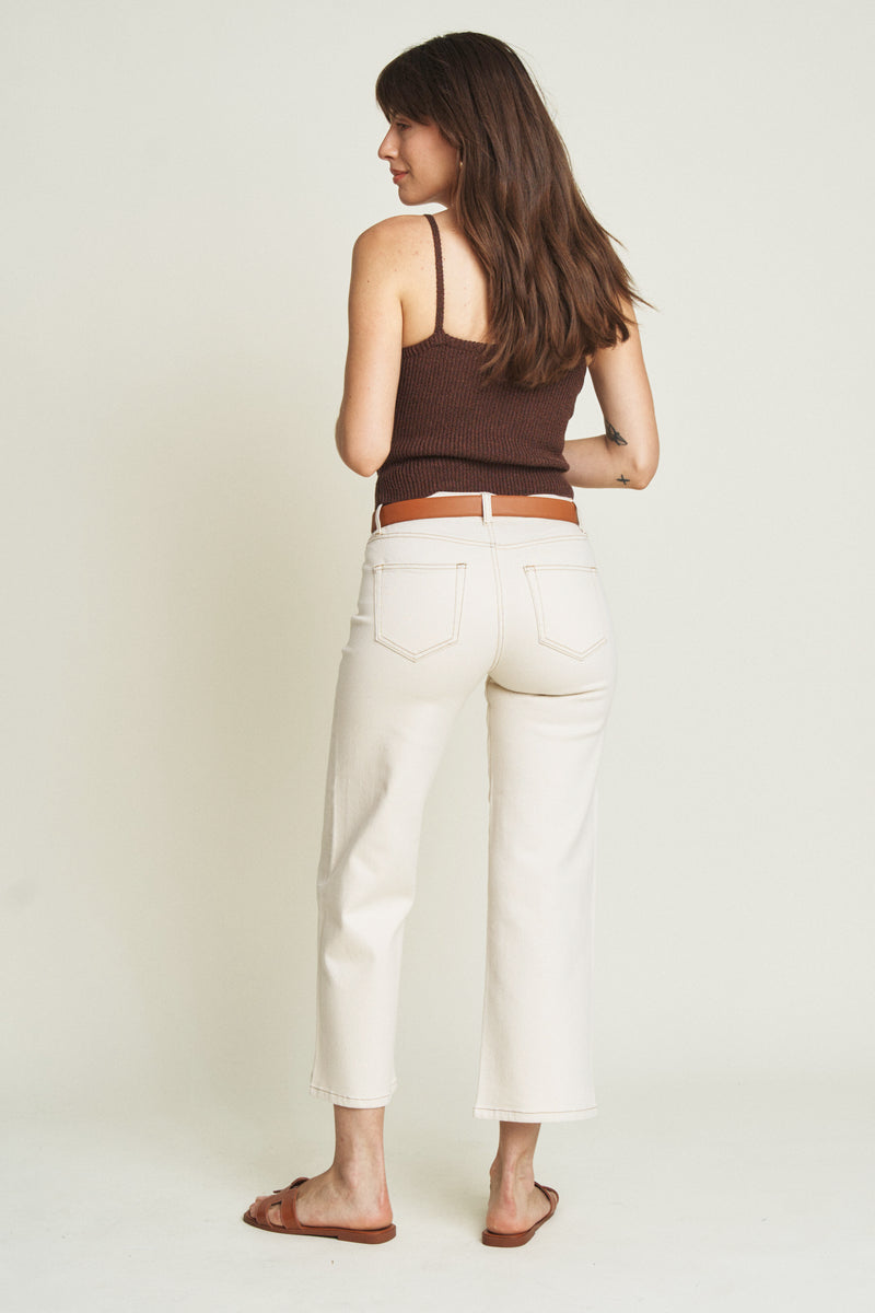Back view of a model in ecru wide-leg ankle crop jeans, highlighting the structured silhouette and clean, minimalist design.