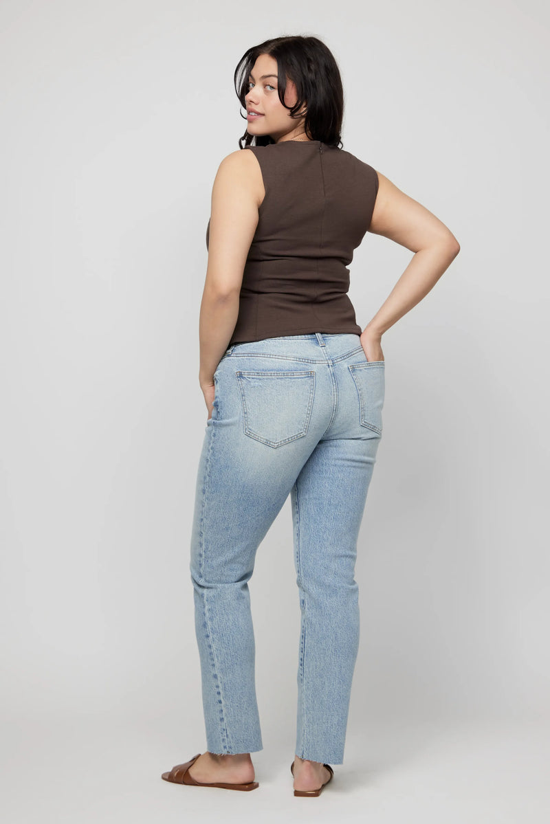 Back view of plus-size high-rise relaxed jeans for women, with clean finish and ankle-grazing hem.