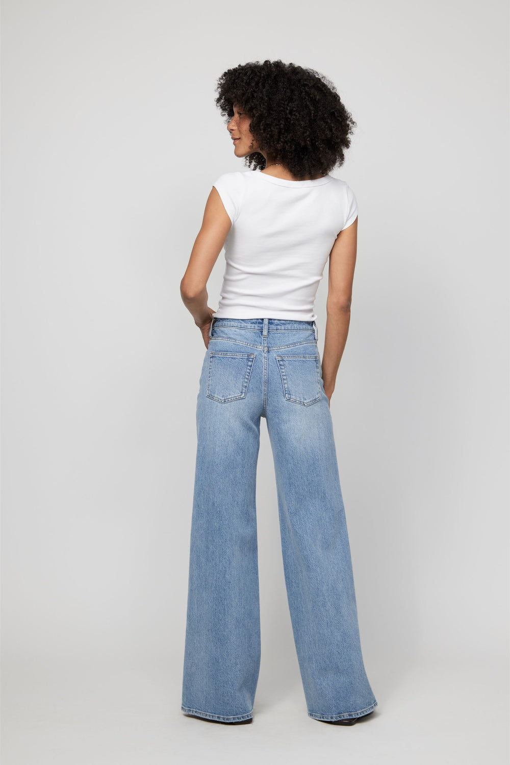 Rear view of high-rise wide-leg denim showing structured waist and flattering back fit.