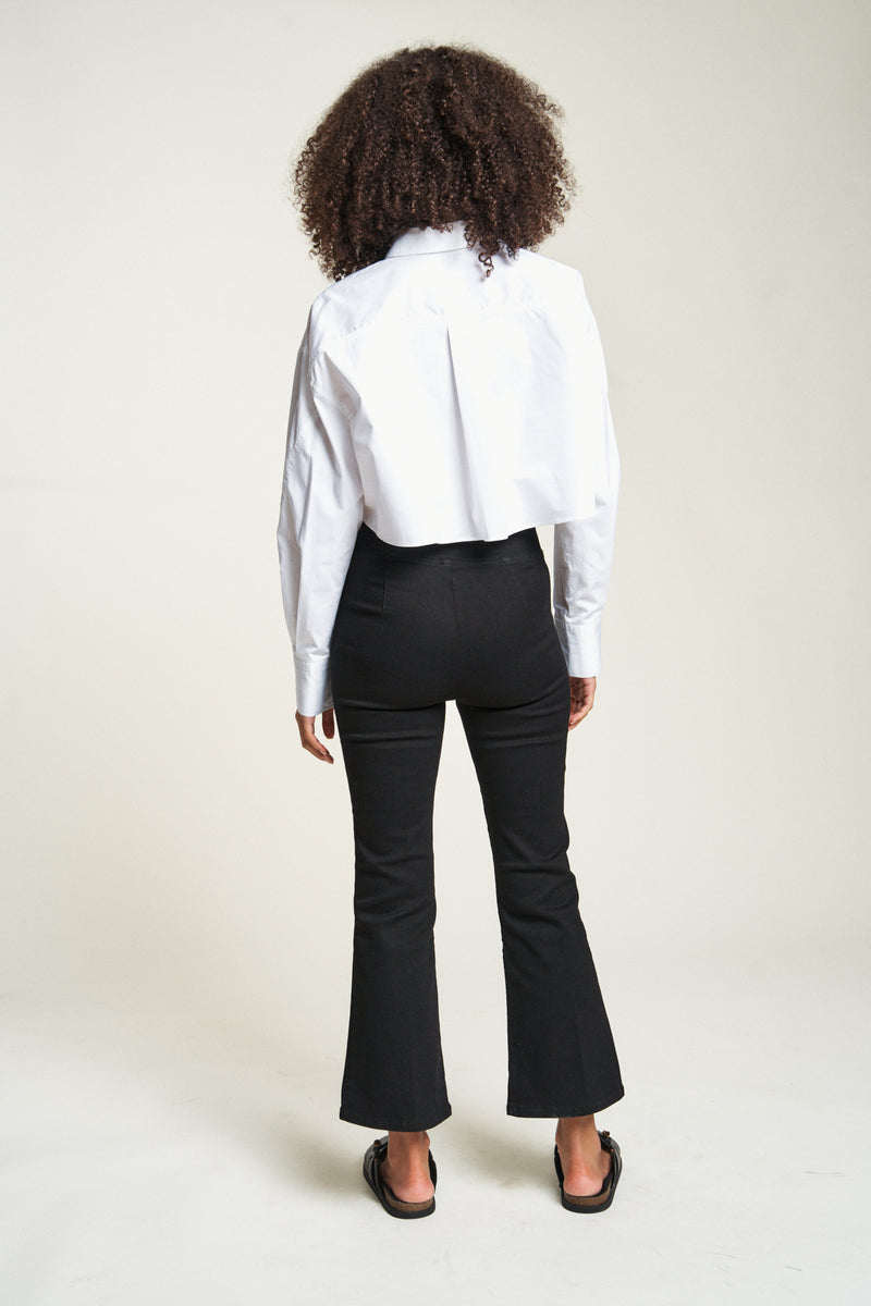 Cropped flare pull-on pants in black, model facing backward, highlighting comfortable fit and cropped flare leg style.