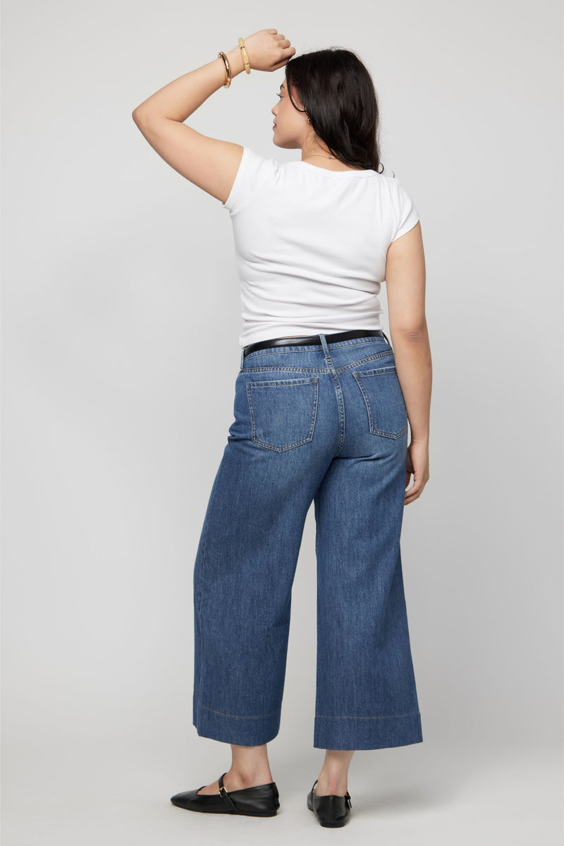 Side view of wide-leg high-rise cropped denim pants for women styled casually with sandals.
