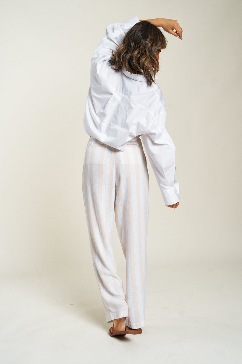 Rear view of lightweight dress pants in a relaxed fit. Paired with a crisp white shirt, ideal for professional settings.