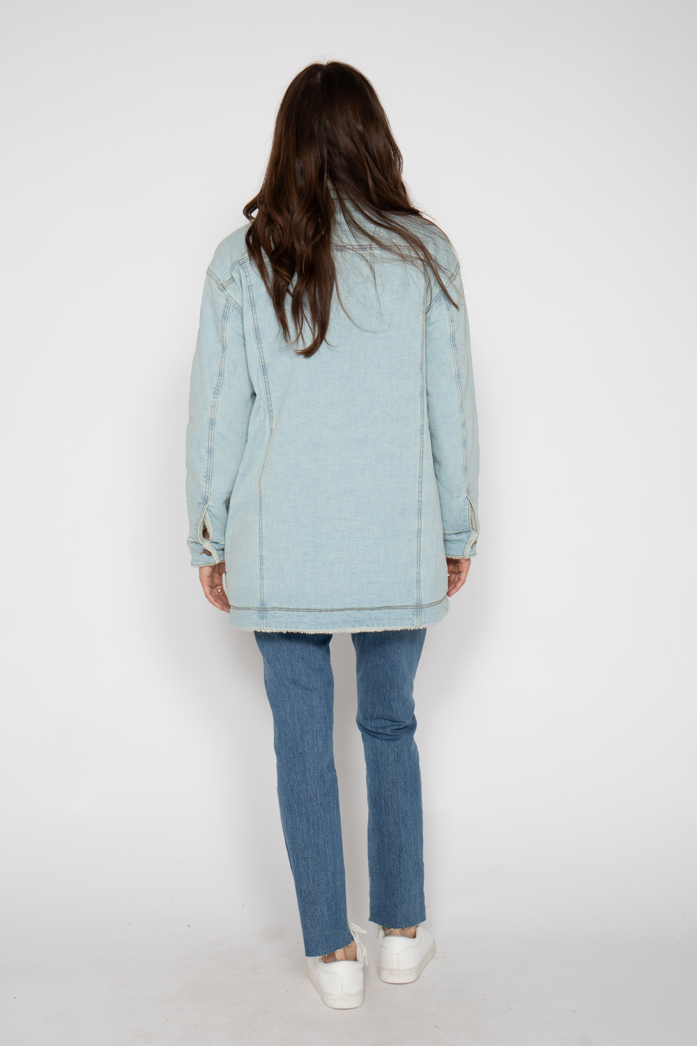 Back view of the same sherpa-lined coat, showcasing its long, straight silhouette.