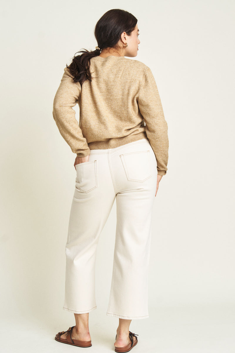 Back view of a plus-size model in ecru wide-leg ankle crop jeans, highlighting the structured silhouette and clean, minimalist design.