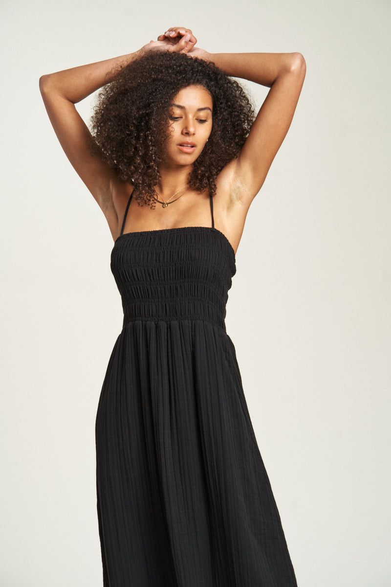 Close-up of white cotton maxi dress, highlighting the smocked upper bodice, soft fabric texture, and delicate shoulder straps for a feminine touch.