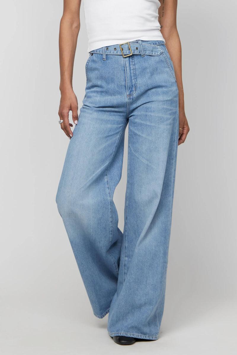 Close-up of high-rise wide-leg jeans with belt detail, highlighting the structured waist and soft-washed fabric.