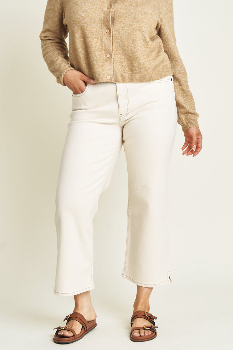 Close-up of ecru wide-leg ankle crop jeans, emphasizing the durable fabric and soft neutral tone.