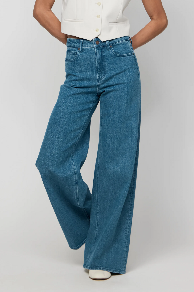 Close-up of medium blue high-rise wide-leg denim, showing clean lines, structured leg, and soft, non-stretch fabric.