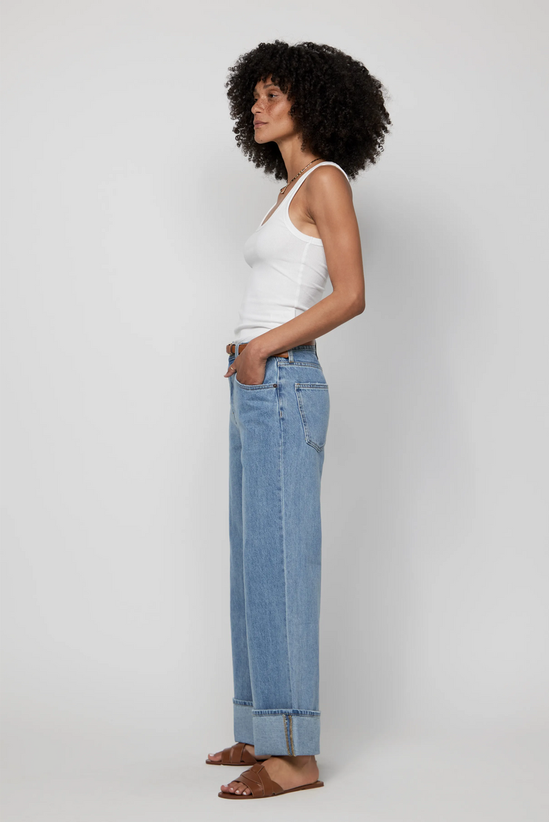 Side profile showcasing mid-rise cuffed wide-leg jeans for women in soft vintage wash.