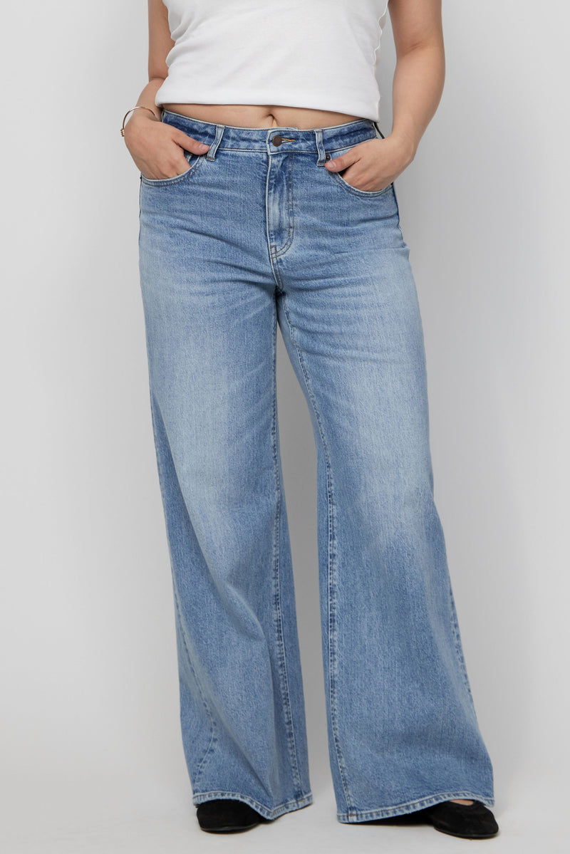 Close-up of high-rise wide-leg denim with clean finish and soft vintage-inspired blue tone.