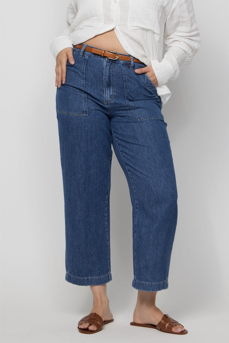 Close-up of plus-size high-rise wide-leg cropped denim trousers with front seaming and relaxed leg.