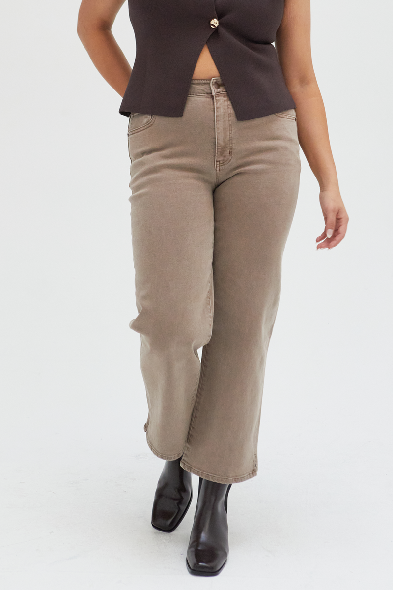 Close-up of brown wide-leg ankle crop jeans, emphasizing the durable fabric and unique earthy tone.