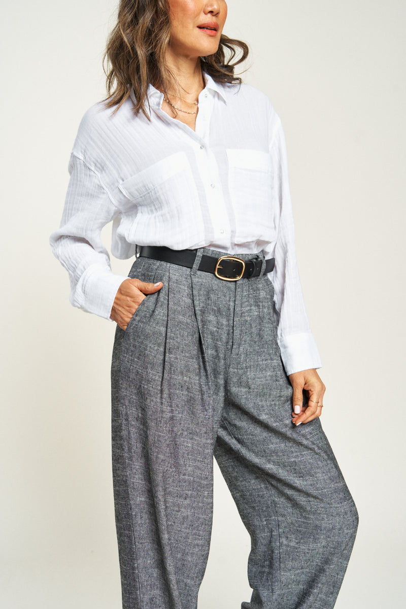 Close-up of pleated trousers, lightweight 100% cotton. High-rise women’s trousers for a chic and comfortable style.