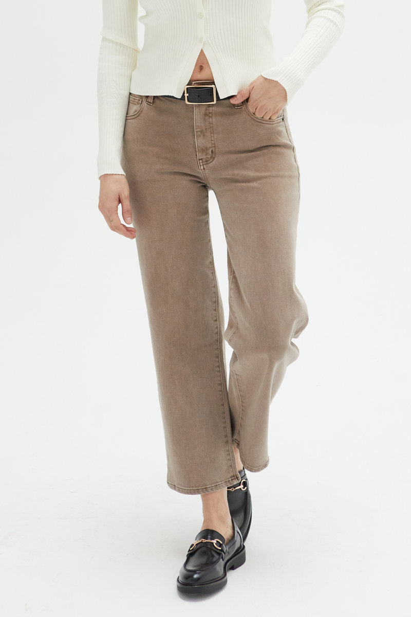 Close-up of brown wide-leg ankle crop jeans, emphasizing the durable fabric and unique earthy tone.