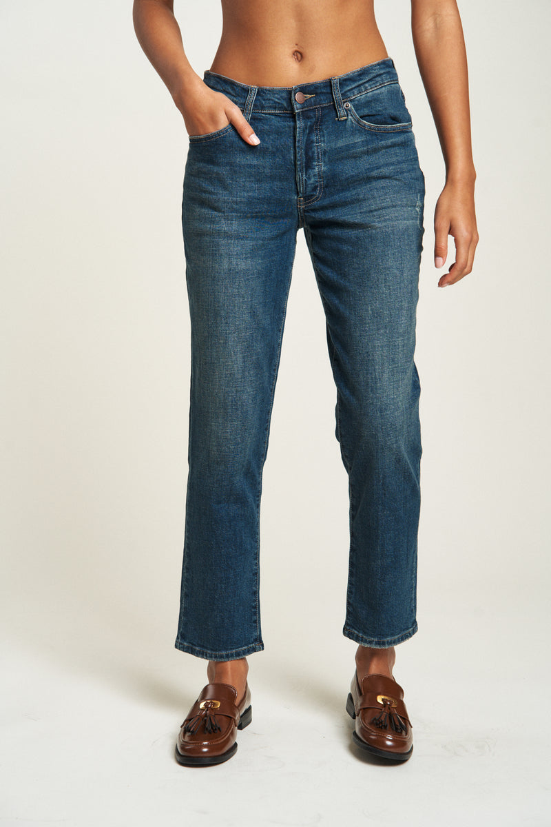 Close-up of high-rise straight leg denim jeans in a vintage wash, showcasing the relaxed fit and comfortable feel of the fabric.