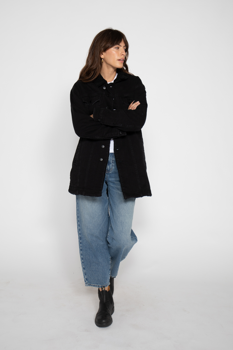 Full-length shot of the model with arms crossed, highlighting the coat&