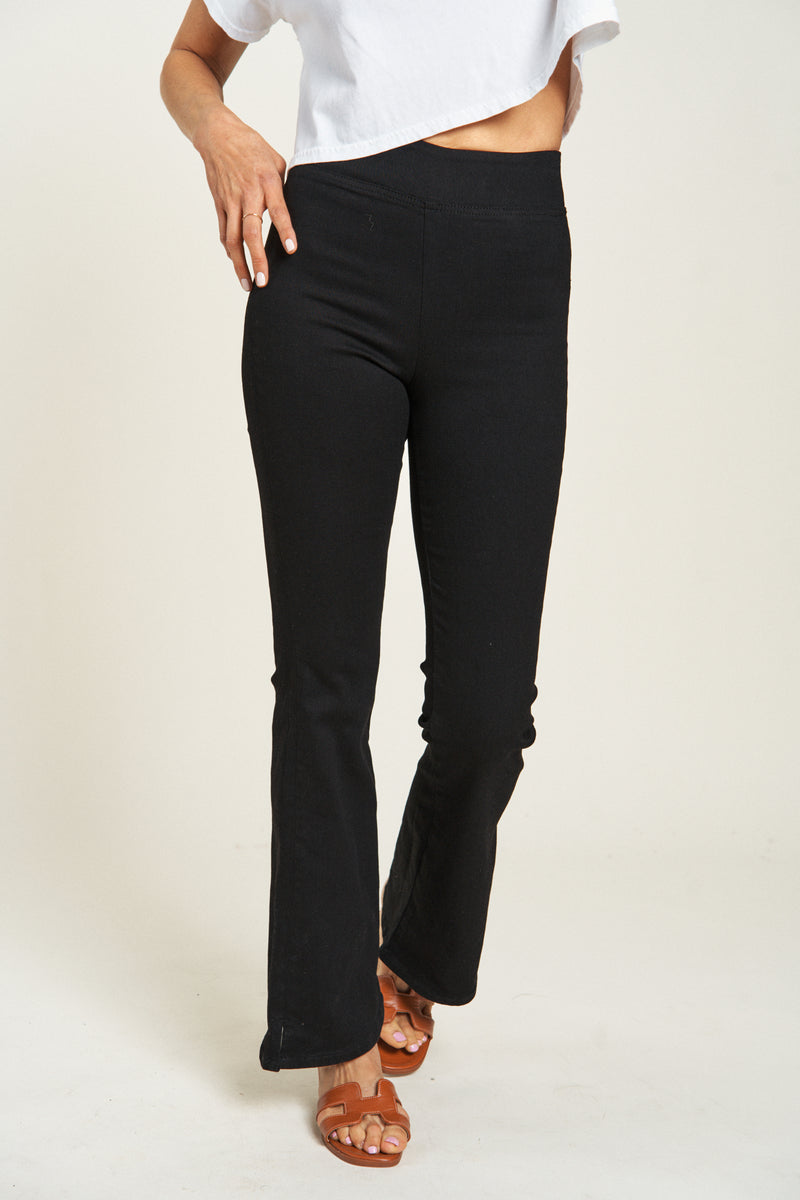 Close-up of black pull-on pants waistband and flare detail, showcasing smooth fit and stretch fabric.