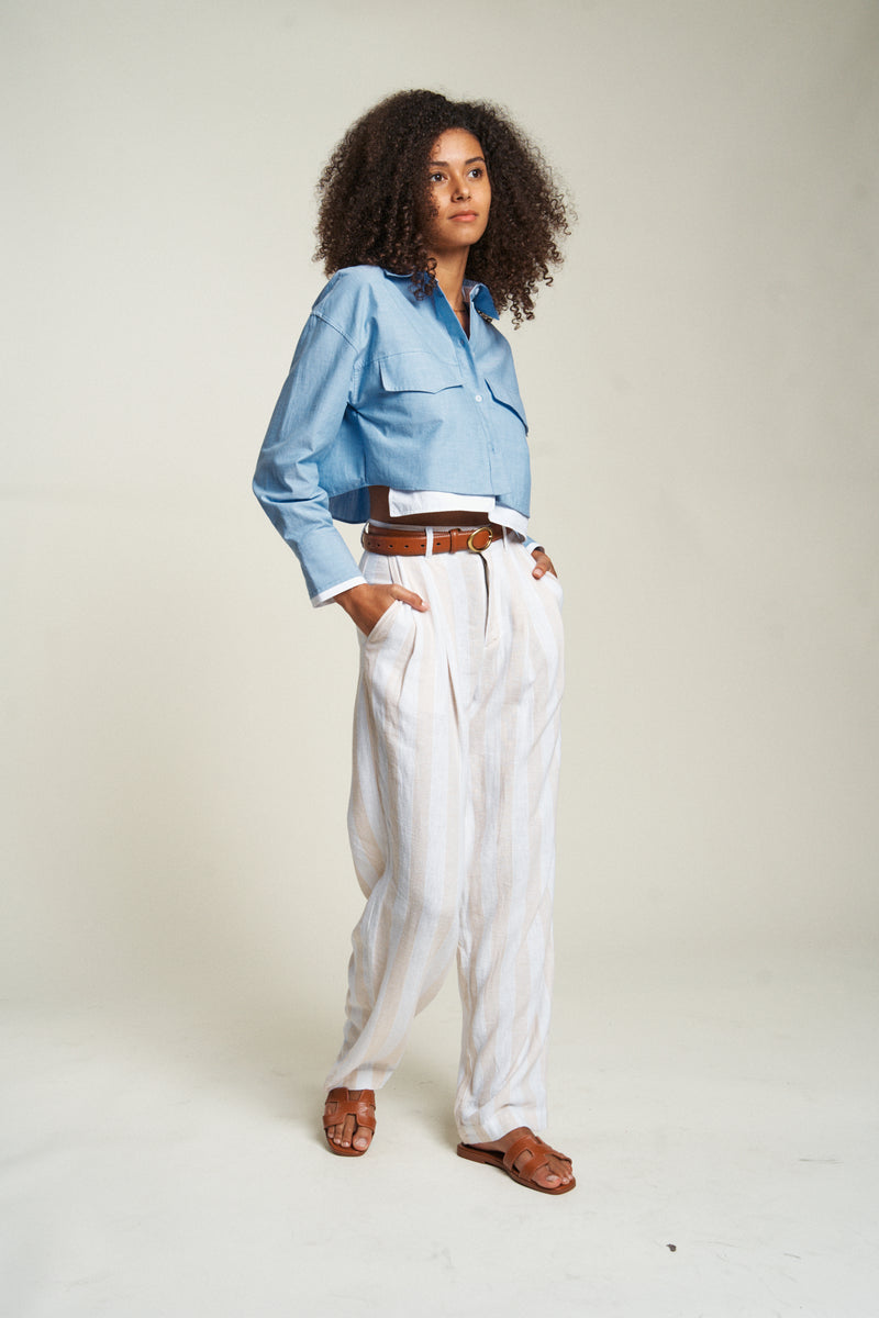 Side view of high-waisted dress pants worn with a white shirt. These women&