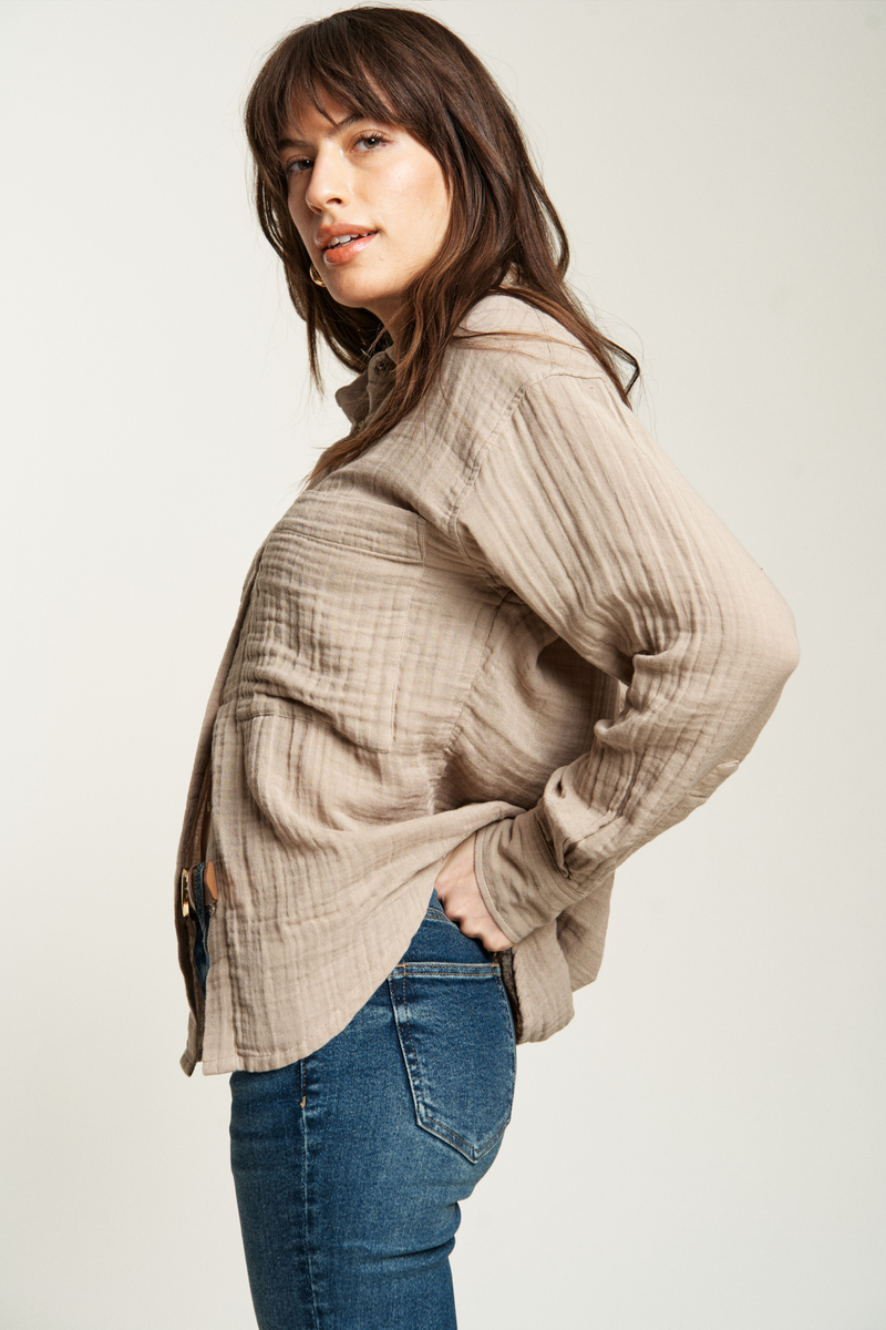 Oversized beige button-up top with a loose, comfortable fit, paired with dark-wash denim for effortless style.