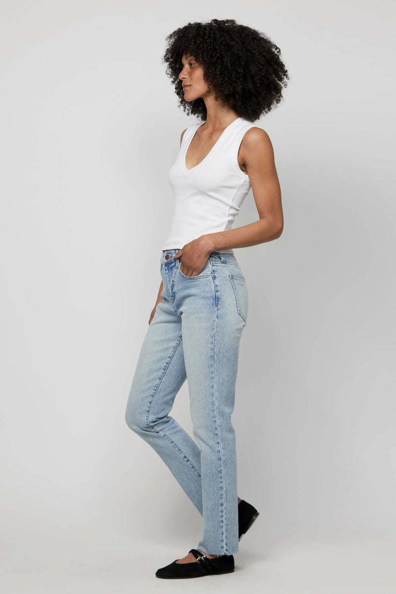Side profile of woman in high-rise relaxed straight leg jeans and black flats.