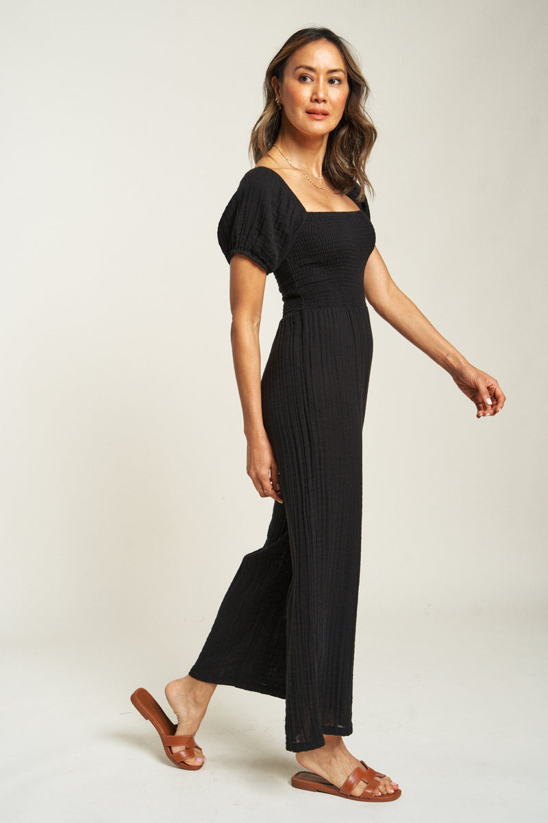 Stylish black romper with a flattering square neckline and loose fit, made from 100% cotton for comfort and ease.