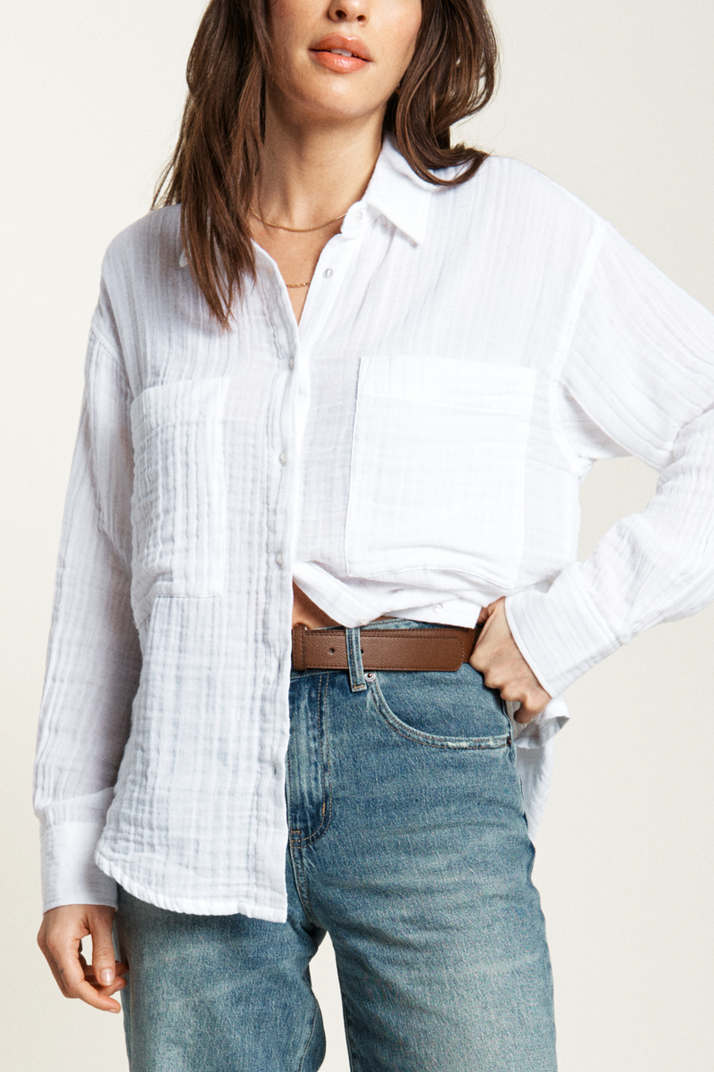 Relaxed-fit button-up top styled casually with a belt and light jeans, offering a comfortable and effortless outfit.