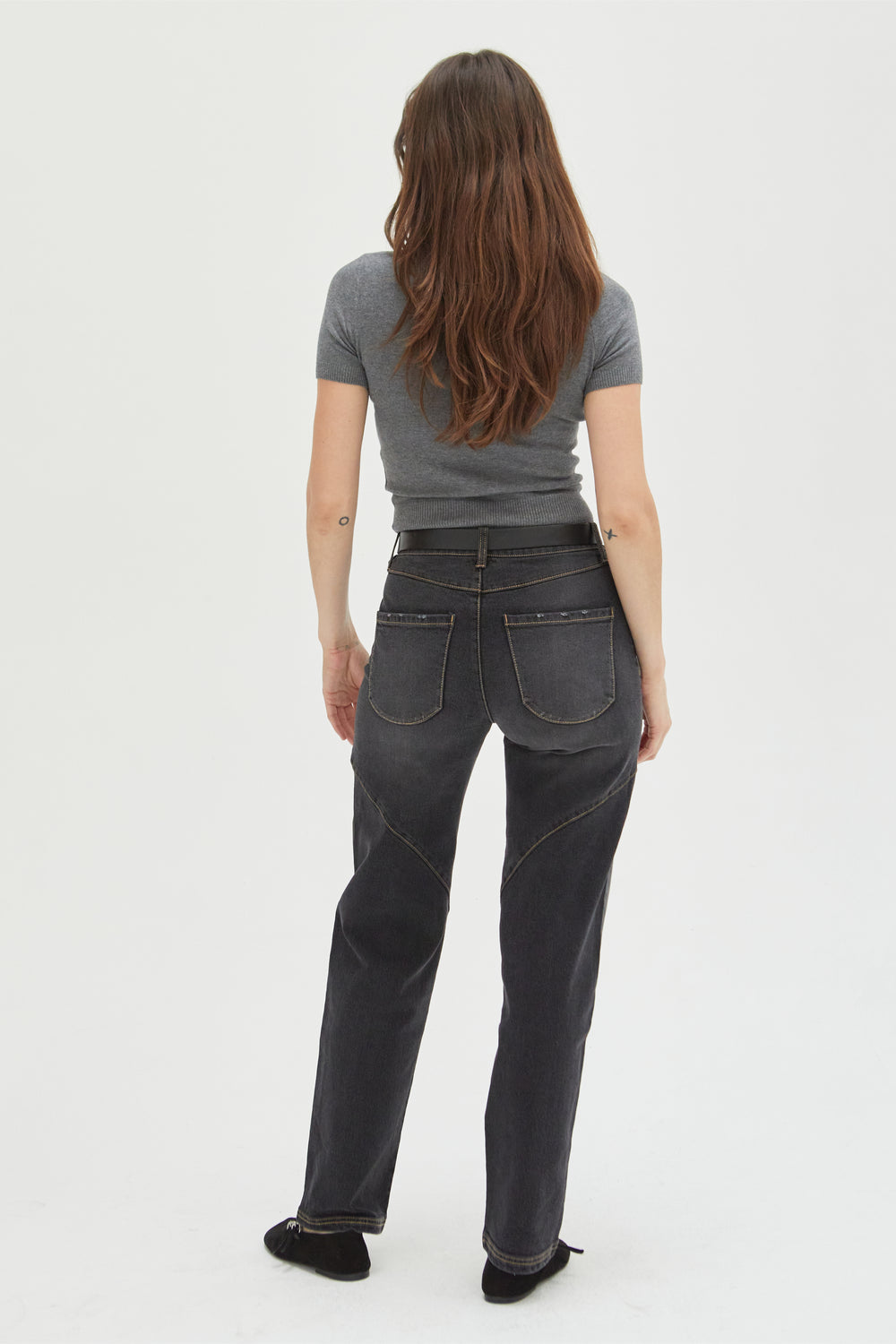 Back view of a model in dark-wash high-rise straight leg jeans, highlighting the classic straight leg cut and durable denim construction.