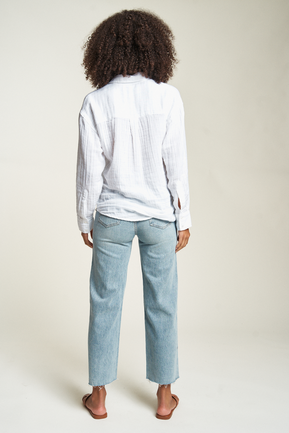 Breezy white button-up top with a relaxed silhouette and long sleeves, offering a versatile look for any season.