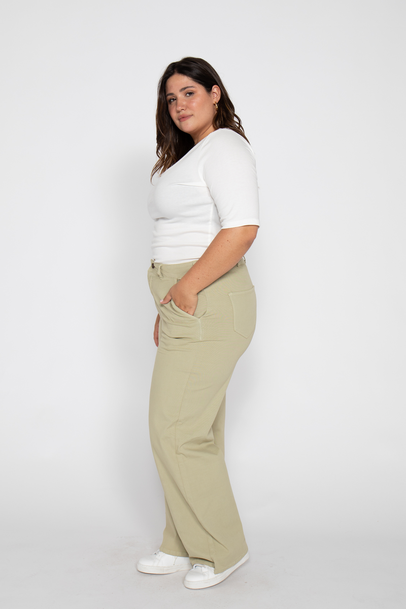 Close-up of high-waisted flare pants for women, highlighting fit on hips and thighs, paired with white sneakers.