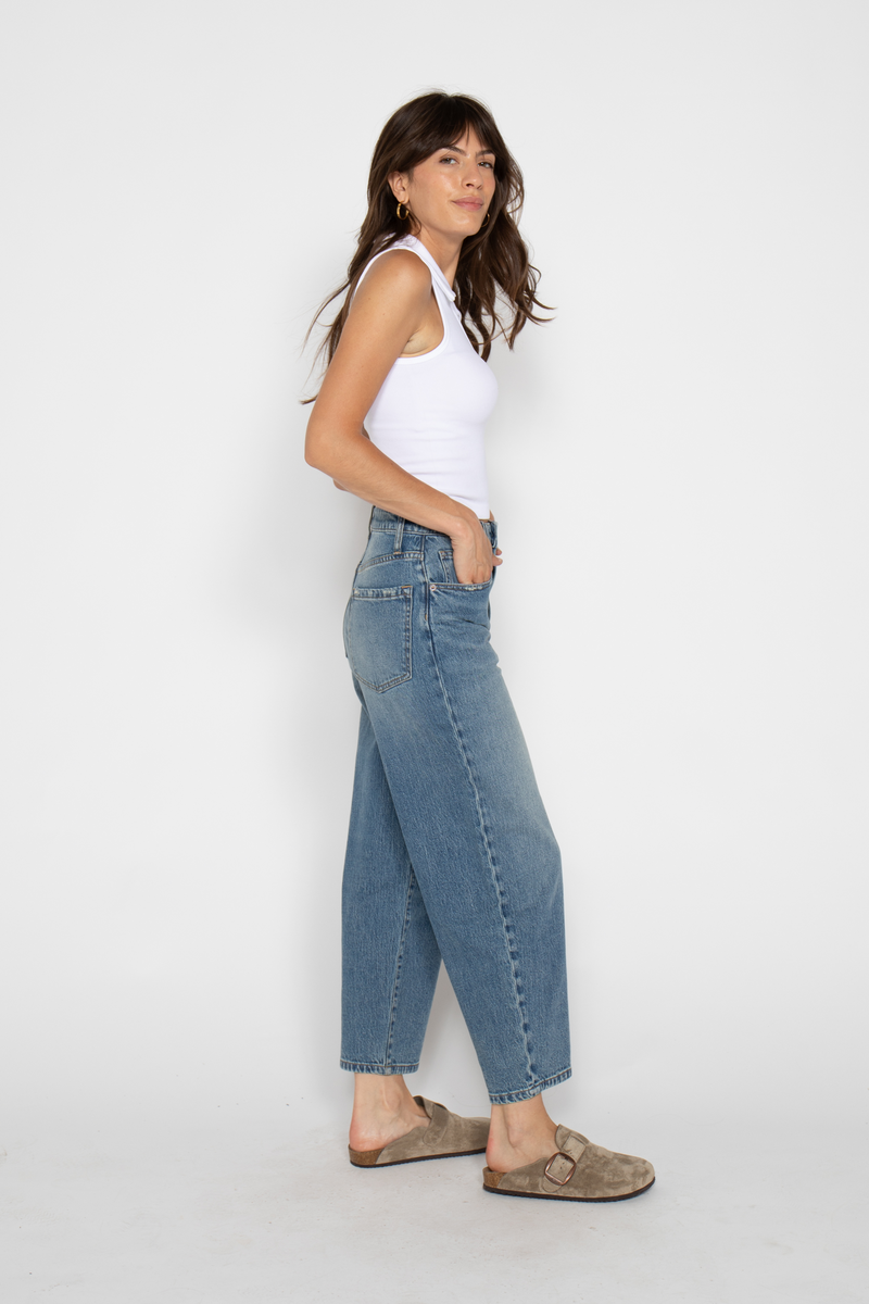Side view of model in high rise wide leg jeans for women, paired with casual footwear, showcasing the cropped vintage style.