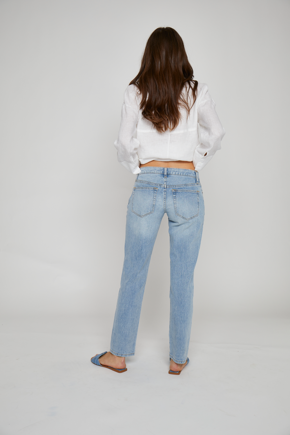 Back view of model in light washed denim, highlighting the flattering straight leg cut and casual low rise fit.