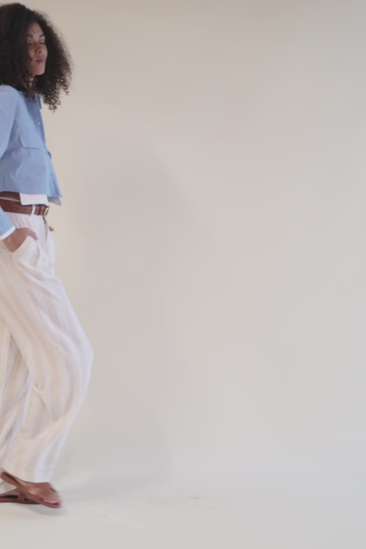Video of model showcasing lightweight high-waisted dress pants paired with a white shirt in motion, highlighting flowy fabric.