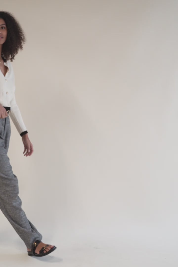 Video of a woman walking in lightweight pleated dress pants. These high-rise trousers combine comfort and elegance, ideal for day-to-night wear.