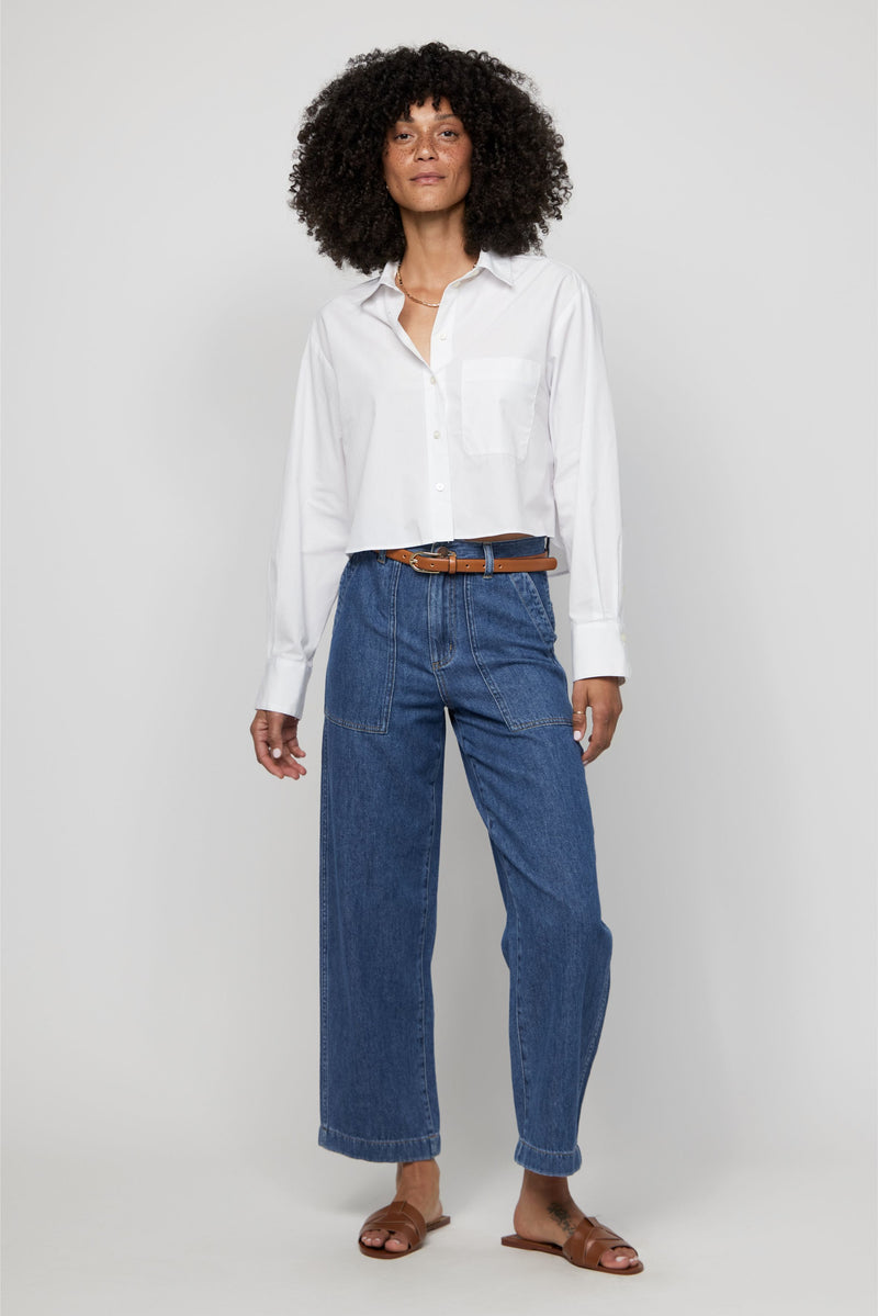 Video of woman modeling high-rise wide-leg cropped denim trousers for women in medium blue.