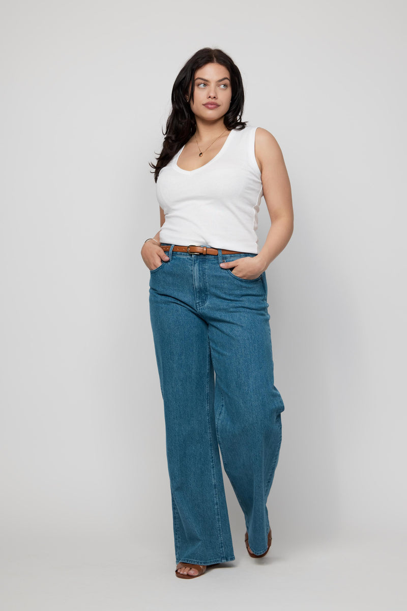 Video of plus-size model walking in high-rise wide-leg jeans in true blue indigo, showing movement and flow of the fabric.