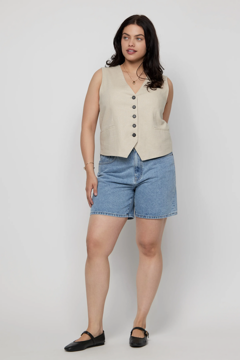Video of plus-size woman wearing high-rise light wash denim shorts with a sleeveless vest top.